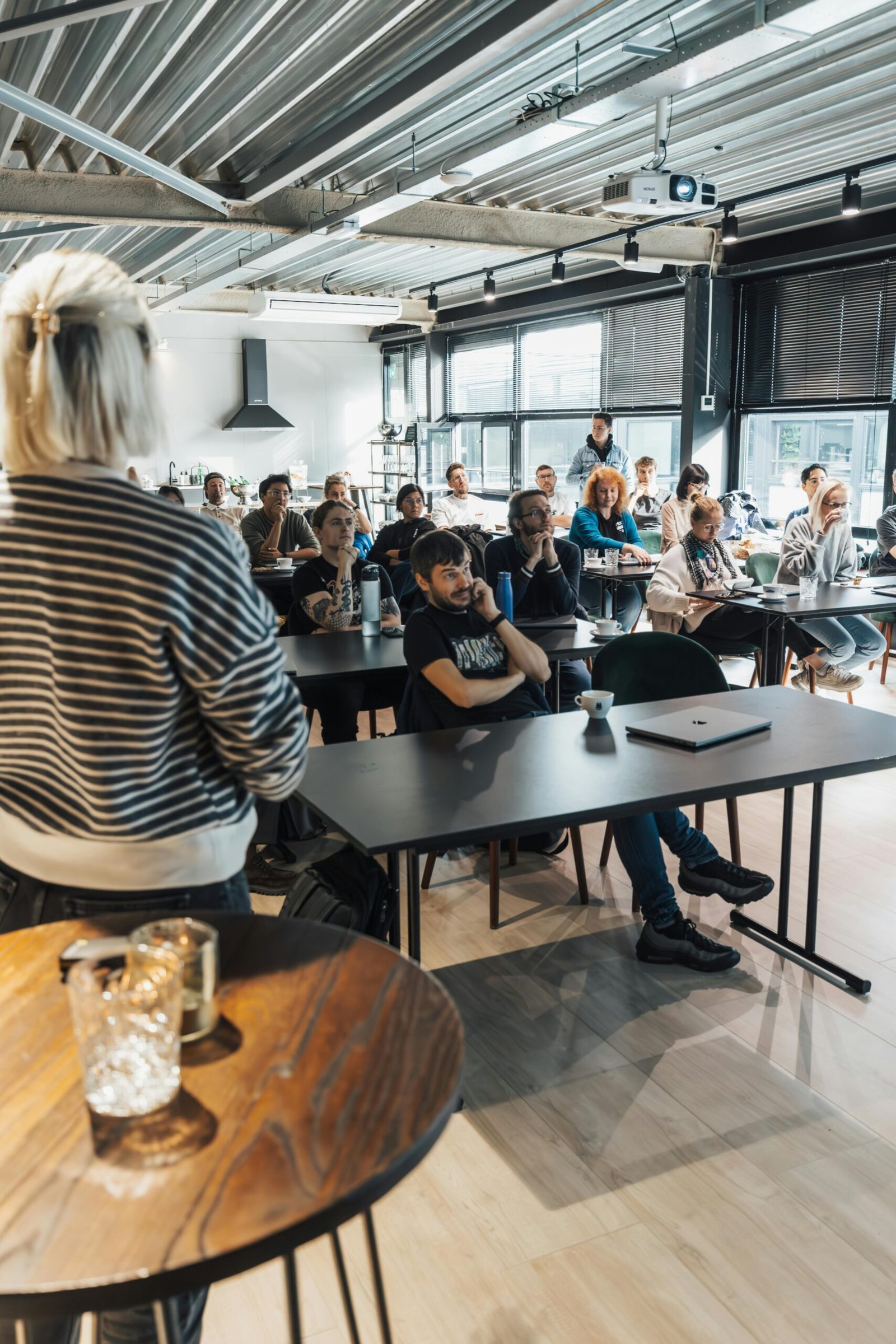 A modern classroom setting with diverse adults engaging in an educational presentation.